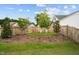 Landscaped backyard with a green lawn, wood fence, flower bed and mature trees at 3528 Olive Glen Dr, Apex, NC 27502