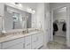 Elegant bathroom featuring dual sinks, a marble-tiled walk-in shower, and a door leading to the walk in closet at 3528 Olive Glen Dr, Apex, NC 27502