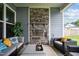 Relaxing covered patio with a stone fireplace, comfortable seating, and views of the backyard at 3528 Olive Glen Dr, Apex, NC 27502