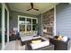 Cozy covered patio with comfortable seating, a stone fireplace, and a ceiling fan for added comfort at 3528 Olive Glen Dr, Apex, NC 27502