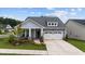 Charming home with a well-manicured lawn, stone accents, and an attached garage at 3528 Olive Glen Dr, Apex, NC 27502