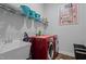 Laundry room with red washer and dryer, sink, shelving with baskets and modern art at 3528 Olive Glen Dr, Apex, NC 27502