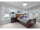 Bright main bedroom with a decorative light fixture, neutral tones, and two large windows at 3528 Olive Glen Dr, Apex, NC 27502