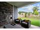 Inviting covered patio with stone fireplace and comfortable seating, perfect for outdoor relaxation and enjoying the backyard view at 3528 Olive Glen Dr, Apex, NC 27502