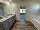 Bright bathroom featuring double vanity with granite countertops and a separate soaking tub at 38 Flatland Dr, Princeton, NC 27569