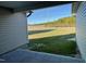 Backyard view from the patio, showcasing a green lawn and a tree line under a blue sky at 39 Flatland Dr, Princeton, NC 27569