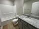 Bathroom featuring a single sink vanity with granite countertops, a shower and toilet combination, and updated finishes at 39 Flatland Dr, Princeton, NC 27569