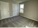 Bedroom with neutral carpet, two white doors, and a window overlooking the side yard at 39 Flatland Dr, Princeton, NC 27569
