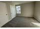 Bedroom with neutral carpet, two white doors, and a window overlooking the side yard at 39 Flatland Dr, Princeton, NC 27569