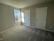 Bedroom with neutral carpet, two white doors, and a window letting in natural light at 39 Flatland Dr, Princeton, NC 27569