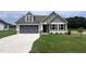 Charming single-Gathering home with a gray garage door, complemented by a well-manicured lawn and elegant architectural details at 39 Flatland Dr, Princeton, NC 27569