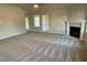 Spacious living room featuring plush gray carpeting, a ceiling fan, and a cozy fireplace at 39 Flatland Dr, Princeton, NC 27569