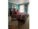 Comfortable bedroom features a bed, and seating area with natural light through large windows at 405 N Massey St, Selma, NC 27576