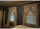 Bedroom with floral wallpaper and two windows dressed in elegant, frilly white curtains, allowing soft natural light at 405 N Massey St, Selma, NC 27576