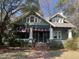 Charming two-story home with a covered porch, brick pathway, manicured landscaping, and awnings on the first floor at 405 N Massey St, Selma, NC 27576