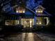 Inviting two-story craftsman home with a brick walkway, covered porch, and warm lights glowing from the windows at 405 N Massey St, Selma, NC 27576