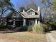 Delightful two-story home with awnings over a screened in porch, mature landscaping, and a brick-lined driveway at 405 N Massey St, Selma, NC 27576