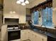 Functional kitchen with white cabinets, black countertops, and modern appliances at 405 N Massey St, Selma, NC 27576