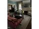 Bright living room with a fireplace, large windows with sheers, vintage sofa, hardwood floors and view of an adjacent room at 405 N Massey St, Selma, NC 27576