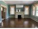 Bright living room with a white fireplace, large windows with sheers, hardwood floors and open layout at 405 N Massey St, Selma, NC 27576