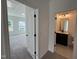 Hallway with a view into a bedroom and a bathroom, showing neutral carpet and modern fixtures at 4302 Emeline Way # 16, Fuquay Varina, NC 27526