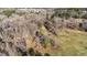 Aerial view showcasing the property's vast land, wooded surroundings, and neighboring properties at 4775 Barber Mill Rd, Clayton, NC 27520