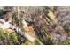 Aerial view of property featuring a one-story house with a circle drive on a lot surrounded by trees at 4775 Barber Mill Rd, Clayton, NC 27520
