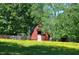 Rustic barn nestled in a field of wildflowers, surrounded by lush green trees and pasture, adding charm to the property at 4775 Barber Mill Rd, Clayton, NC 27520