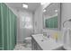 Clean bathroom featuring tile floors, a white vanity, and a shower with a green curtain at 4775 Barber Mill Rd, Clayton, NC 27520