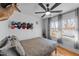 Cozy bedroom featuring hardwood floors, ample natural light, a ceiling fan, and unique decor at 4775 Barber Mill Rd, Clayton, NC 27520