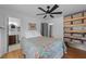 Bedroom featuring hardwood floors, a ceiling fan, built in shelves, and adjacent bathroom at 4775 Barber Mill Rd, Clayton, NC 27520