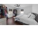 Bright bedroom featuring wood floors, white walls, a ceiling fan, and organized closet space at 4775 Barber Mill Rd, Clayton, NC 27520