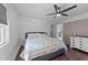 Well-lit bedroom featuring wood floors, white walls, a ceiling fan, and an adjacent room at 4775 Barber Mill Rd, Clayton, NC 27520