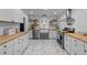 Bright kitchen boasts white cabinets, butcher block countertops, open shelving, and stainless steel appliances at 4775 Barber Mill Rd, Clayton, NC 27520