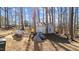 View of an outbuilding and the backyard with mature trees and a propane tank at 4775 Barber Mill Rd, Clayton, NC 27520