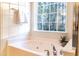 Bright bathroom with a white tiled tub and a large window offering a view of nature at 503 Gray Marble Rd, Morrisville, NC 27560