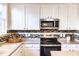 Modern kitchen with white cabinets, mosaic backsplash, and stainless steel appliances at 503 Gray Marble Rd, Morrisville, NC 27560