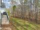 View of backyard with grass and trees, plus a partial view of deck steps at 5032 Big Creek Rd, Raleigh, NC 27613