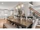 Open-concept dining room featuring a large wooden table and stairs nearby at 5032 Big Creek Rd, Raleigh, NC 27613