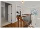 Stairway landing with hardwood floors and view of foyer with large window and modern chandelier at 5032 Big Creek Rd, Raleigh, NC 27613
