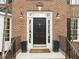Elegant front entrance with sidelights, decorative hardware, and stylish outdoor lanterns at 5032 Big Creek Rd, Raleigh, NC 27613