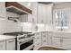 An open white kitchen with stainless appliances, ample counter space, and a tile backsplash is bright and welcoming at 5032 Big Creek Rd, Raleigh, NC 27613