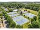 Aerial view of a community tennis court and pool area surrounded by lush trees at 604 Copperline Dr # 108, Chapel Hill, NC 27516