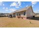 Tan house with a well-maintained yard, solar panels, and a playhouse on a partially cloudy day at 66 Newbury Dr, Angier, NC 27501