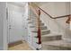 Welcoming home entryway with carpeted stairs, white door, and wood railing at 66 Newbury Dr, Angier, NC 27501