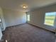 Bright bedroom featuring neutral carpet, base trim and two windows at 72 E Victory View Ter, Smithfield, NC 27577