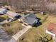 Aerial view of the property showcasing the house, detached garage, fenced yard, and landscaping at 74 Azalea Dr, Roxboro, NC 27573