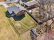 Aerial view of a spacious, fenced backyard with mature trees and a firepit area, perfect for outdoor entertaining at 74 Azalea Dr, Roxboro, NC 27573