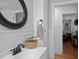 Bathroom sink and vanity with black faucet and a woven basket with green plant in a well-lit space at 74 Azalea Dr, Roxboro, NC 27573