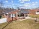 Charming brick home featuring a covered front porch, gray roof, and a well-maintained front yard at 74 Azalea Dr, Roxboro, NC 27573